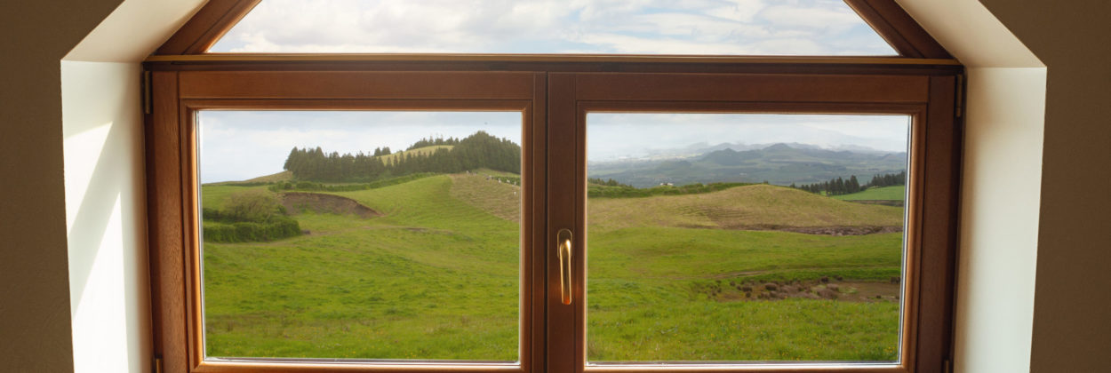 Closed window and beautiful picture outside, nature view, resort and resting. Sunny summers or spring day with green grass, sea or ocean, bright and vibrant colors. Tourism, hotels or home mood.